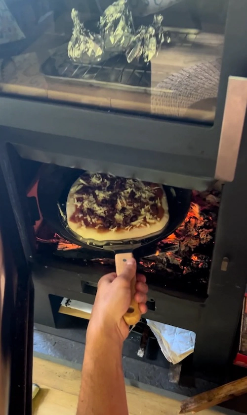 Horneando pizza en la recámara de la chimenea.